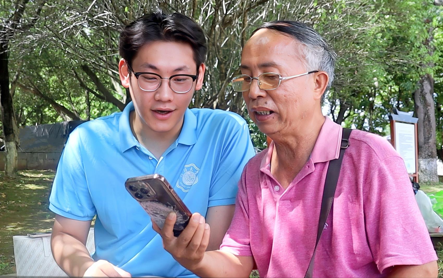 圖為實踐團成員與當?shù)乩先艘黄饘W習誦讀古詩